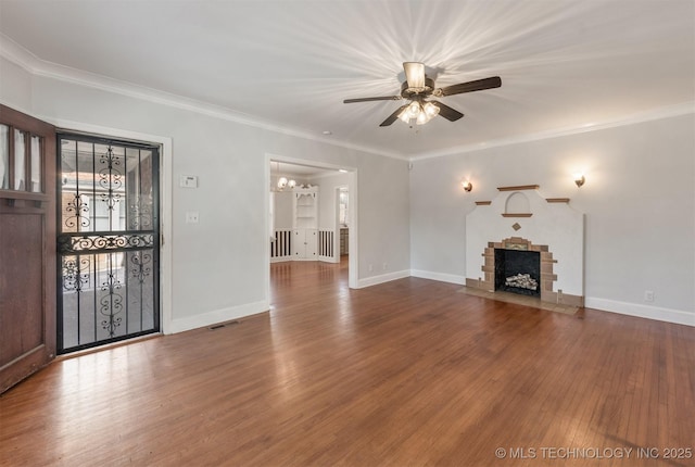 1531 S Florence Ave, Tulsa, OK 74104 - unfurnished living room featuring ceiling fan with notable chandelier, hardwood / wood-style floors, ornamental molding, and a stone fireplace