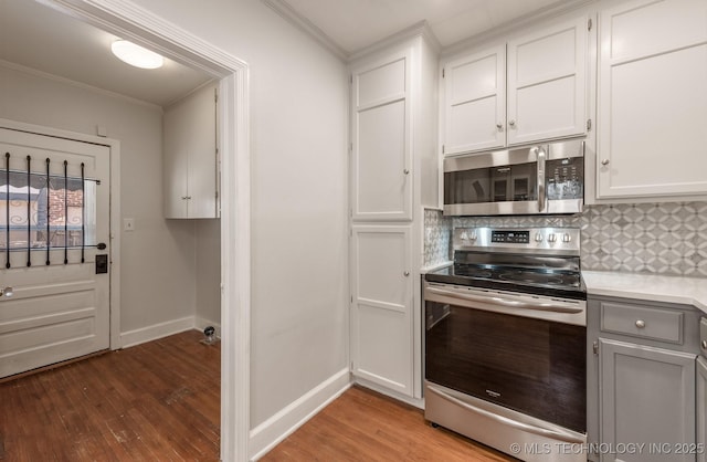 1531 S Florence Ave, Tulsa, OK 74104 - kitchen featuring hardwood / wood-style floors, white cabinets, stainless steel appliances, and tasteful backsplash