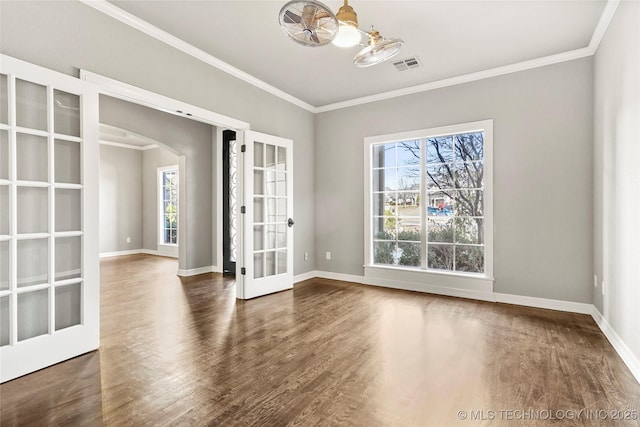 spare room featuring dark hardwood / wood-style flooring, crown molding, and french doors