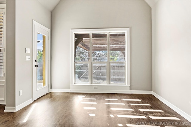 entrance foyer with dark wood-type flooring, a healthy amount of sunlight, and vaulted ceiling