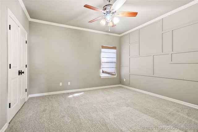 carpeted spare room featuring ceiling fan and ornamental molding