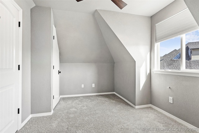 bonus room featuring ceiling fan, light carpet, and vaulted ceiling