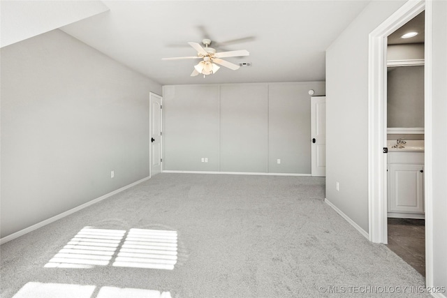 unfurnished bedroom with ceiling fan, light colored carpet, ensuite bath, and sink