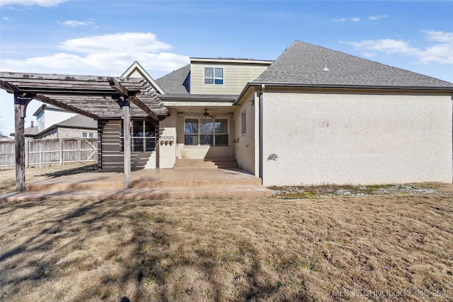 rear view of house featuring ceiling fan, a patio area, and a lawn