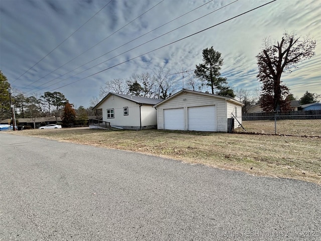 view of front facade with a front yard, an outbuilding, and a garage