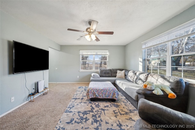 living room with ceiling fan, plenty of natural light, a textured ceiling, and light carpet