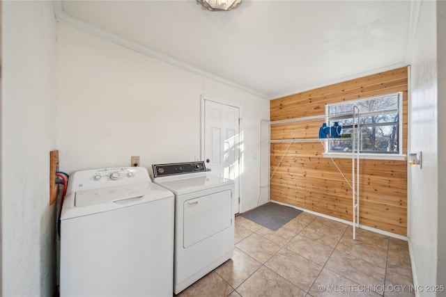 washroom featuring ornamental molding, wooden walls, light tile patterned floors, and separate washer and dryer