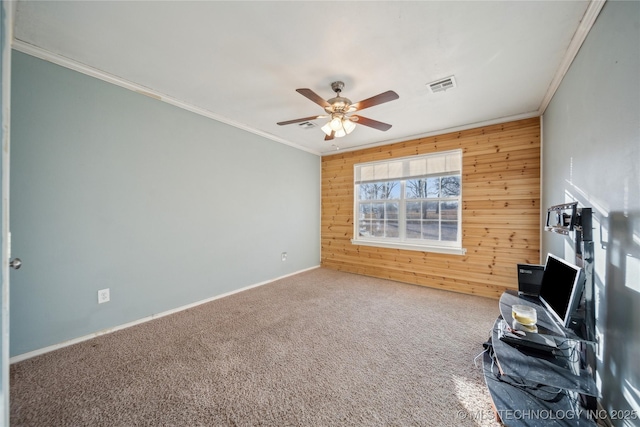 unfurnished office with ceiling fan, carpet, crown molding, and wooden walls