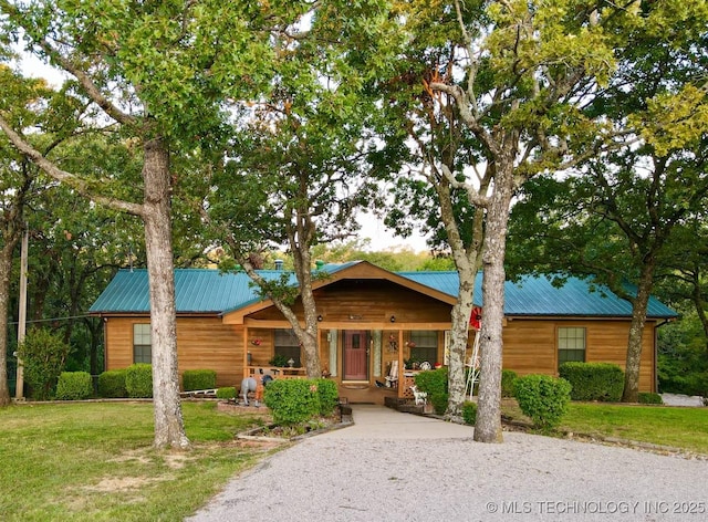 log cabin with covered porch and a front yard