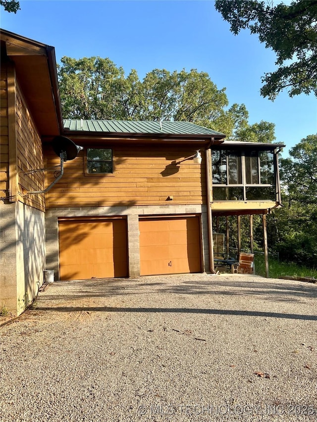 exterior space featuring a garage and a sunroom