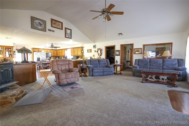 carpeted living room with vaulted ceiling and ceiling fan