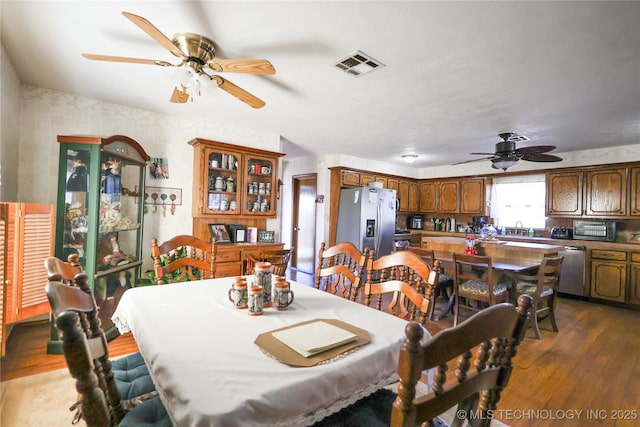 dining space featuring sink, dark wood-type flooring, and ceiling fan