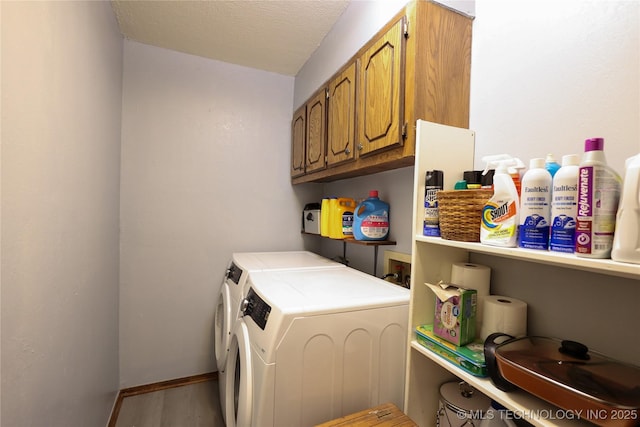 laundry area with washer and dryer, cabinets, and a textured ceiling