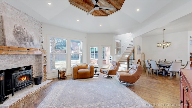 living room featuring ceiling fan with notable chandelier and light hardwood / wood-style floors