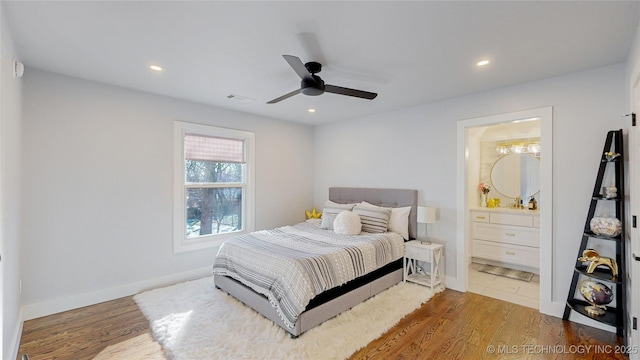 bedroom featuring hardwood / wood-style flooring, ensuite bathroom, and ceiling fan