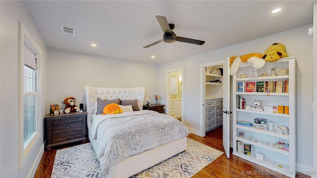 bedroom featuring ensuite bath, dark hardwood / wood-style floors, and ceiling fan