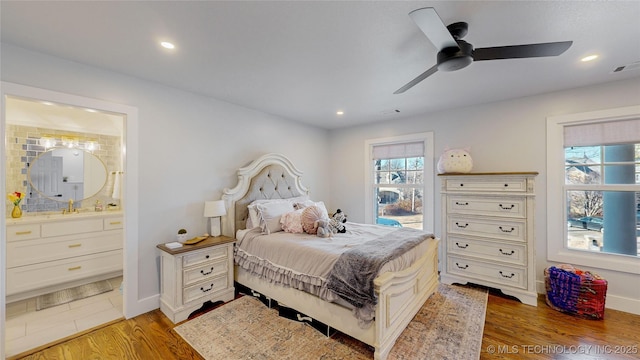 bedroom featuring hardwood / wood-style flooring, ceiling fan, and connected bathroom