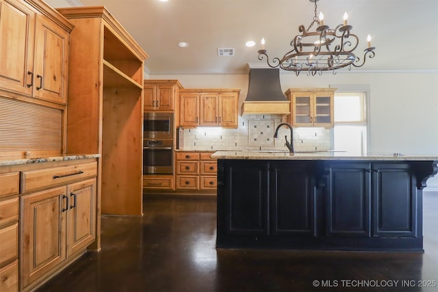 kitchen featuring a breakfast bar area, light stone countertops, custom range hood, and a center island with sink