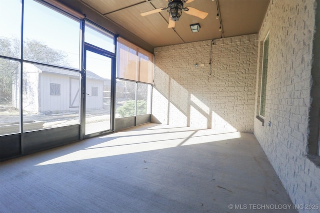 unfurnished sunroom with ceiling fan