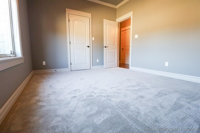 unfurnished bedroom with crown molding and carpet flooring