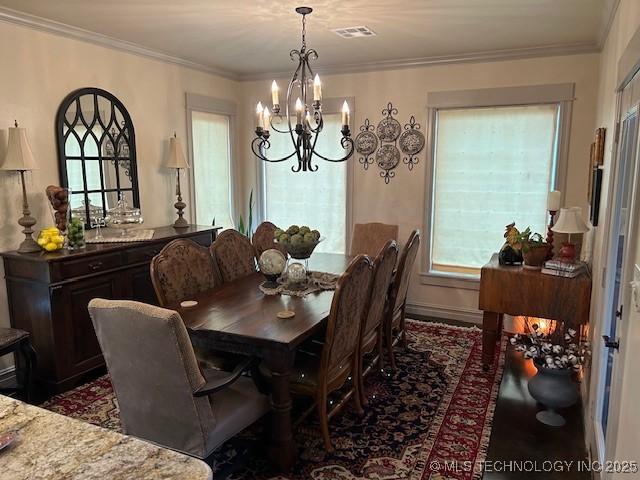 dining space featuring crown molding and a chandelier