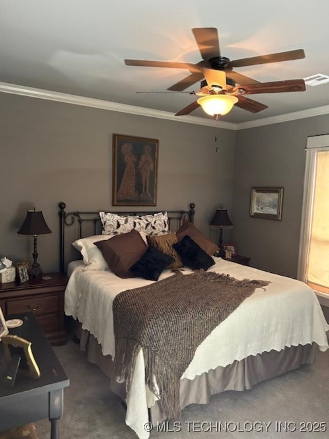 carpeted bedroom with ceiling fan and ornamental molding