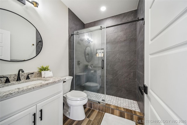 bathroom with vanity, an enclosed shower, and toilet