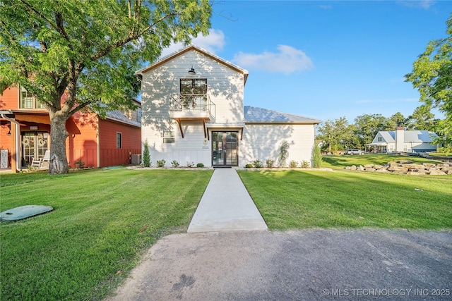 view of front of house featuring cooling unit and a front yard