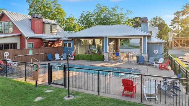 back of property with a gazebo, a fenced in pool, and a patio area