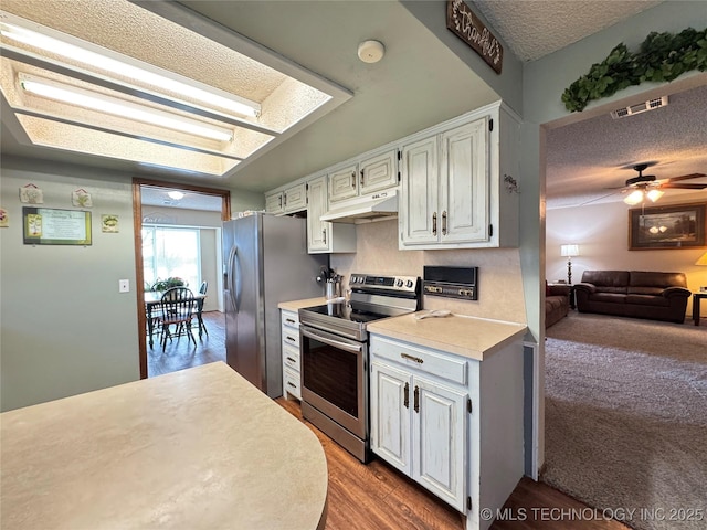 kitchen with ceiling fan, appliances with stainless steel finishes, wood-type flooring, and white cabinets