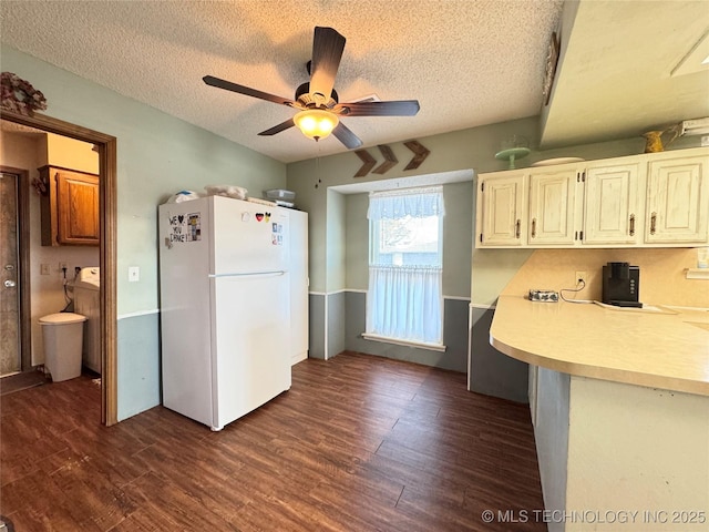 kitchen featuring ceiling fan, white fridge, dark hardwood / wood-style floors, and a textured ceiling