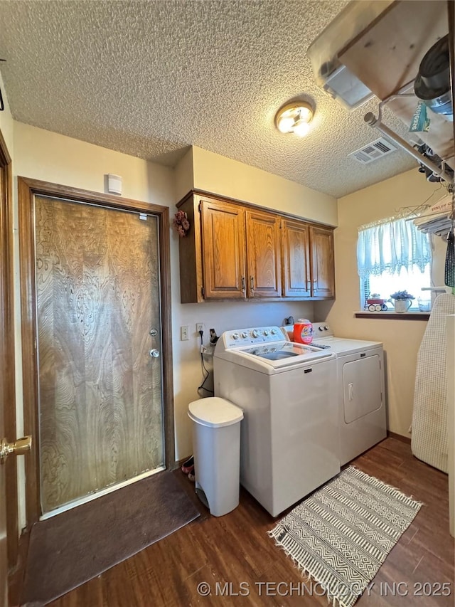 laundry area with independent washer and dryer, cabinets, dark hardwood / wood-style floors, and a textured ceiling