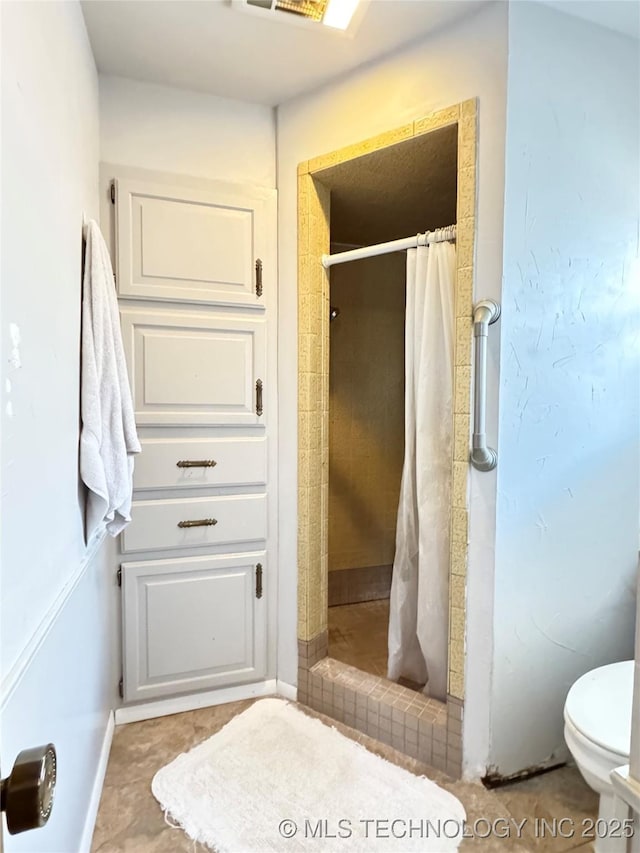 bathroom featuring tile patterned floors, toilet, and curtained shower