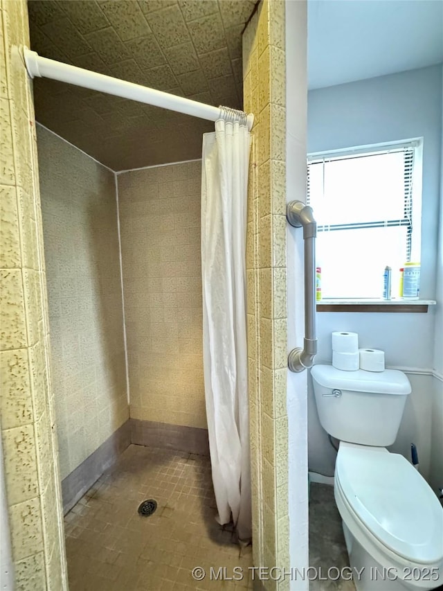 bathroom featuring curtained shower and toilet