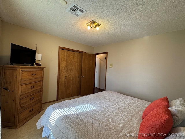 carpeted bedroom with a closet and a textured ceiling