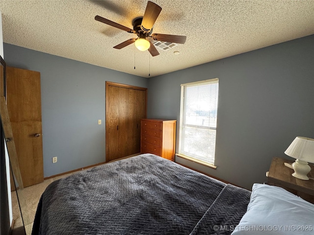 bedroom with light carpet, a textured ceiling, a closet, and ceiling fan