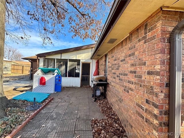 view of patio / terrace with a sunroom and a grill