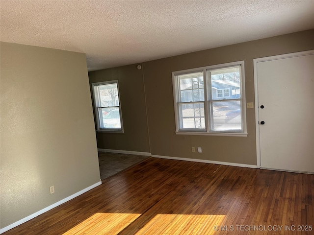 entryway featuring dark wood-type flooring and a textured ceiling