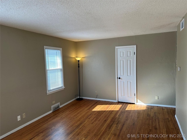 unfurnished room with wood-type flooring and a textured ceiling