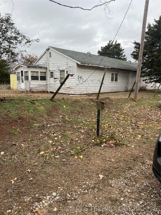 view of side of home featuring fence