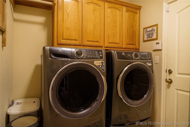 washroom with washer and clothes dryer and cabinets