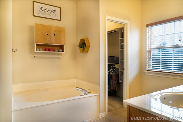 bathroom featuring vanity, tile patterned flooring, and a washtub