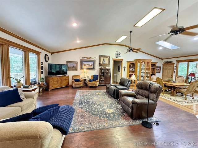 living room with ornamental molding, dark hardwood / wood-style floors, and vaulted ceiling with skylight