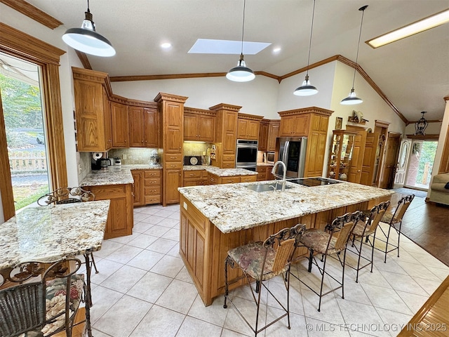 kitchen with hanging light fixtures, backsplash, a spacious island, and appliances with stainless steel finishes