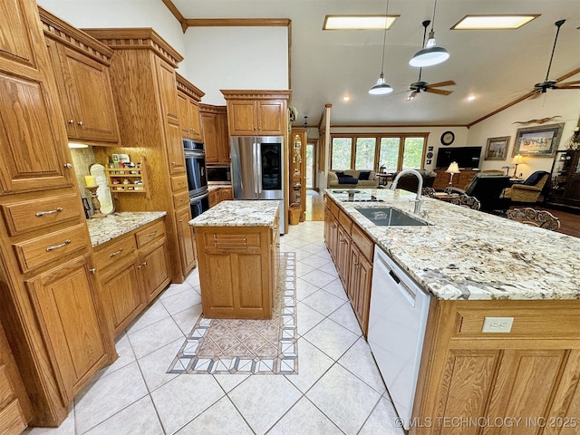 kitchen featuring sink, appliances with stainless steel finishes, hanging light fixtures, vaulted ceiling, and a large island with sink