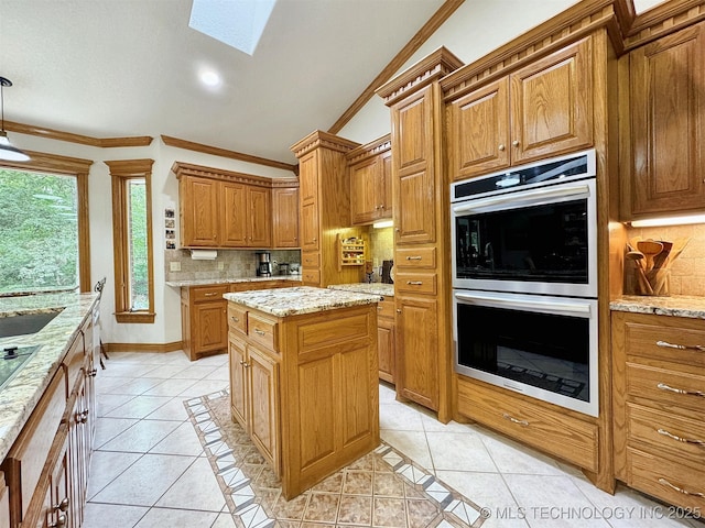 kitchen featuring light tile patterned floors, double oven, tasteful backsplash, light stone counters, and a kitchen island