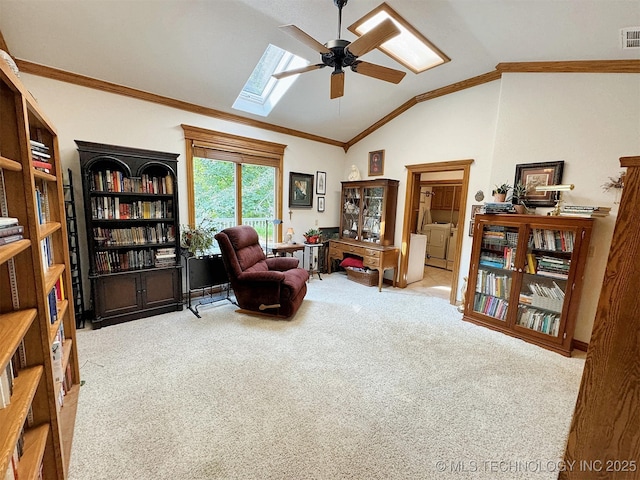 living area with crown molding, ceiling fan, lofted ceiling with skylight, and light carpet