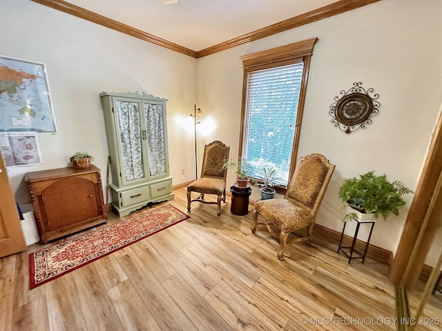 living area featuring crown molding and light hardwood / wood-style flooring