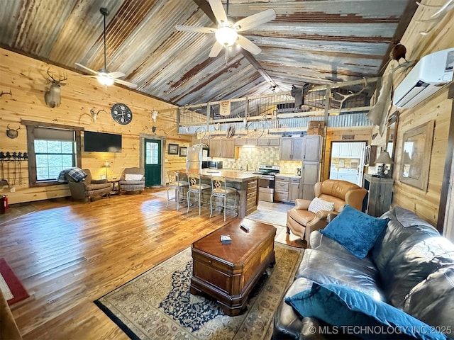 living room with hardwood / wood-style flooring, ceiling fan, beam ceiling, a wall mounted air conditioner, and a healthy amount of sunlight