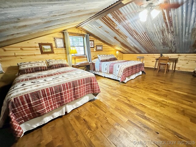 bedroom with wood ceiling, ceiling fan, hardwood / wood-style floors, and wood walls